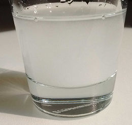 Halbaufgelöstes Kreatin in einem Glas mit Wasser
